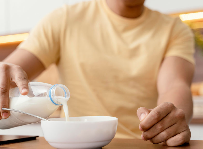 portrait-man-home-pouring-milk-bowl